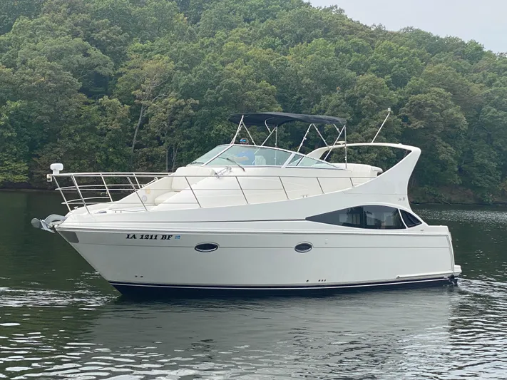 Yacht Photos Pics 2006 Carver 36 Mariner yacht on calm water, surrounded by lush greenery.