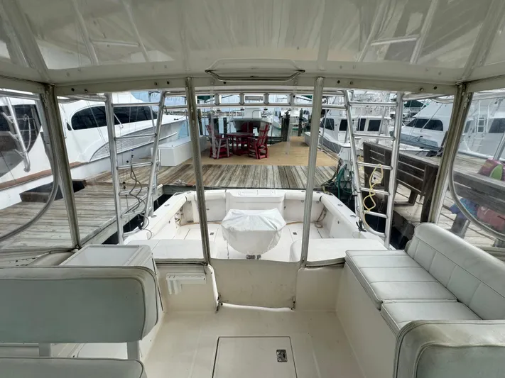 Fishy Business Yacht Photos Pics 2005 Cabo 35 Express boat interior with dock view, featuring white seating and spacious layout.