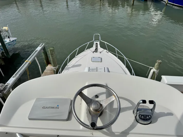 Fishy Business Yacht Photos Pics 2005 Cabo 35 Express boat helm with Garmin navigation, docked in calm waters.