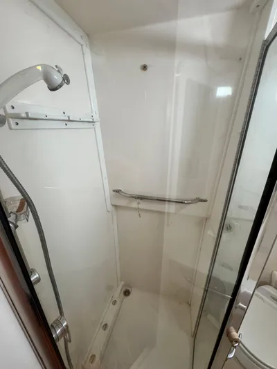 Fishy Business Yacht Photos Pics Compact shower in 2005 Cabo 35 Express boat, featuring a handheld showerhead and safety rail.