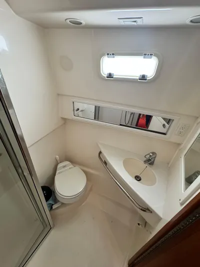 Fishy Business Yacht Photos Pics 2005 Cabo 35 Express boat bathroom with toilet, sink, and window.