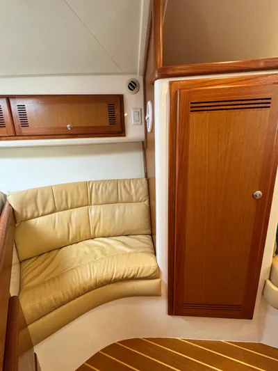 Fishy Business Yacht Photos Pics Interior of a 2005 Cabo 35 Express boat with beige seating and wooden cabinetry.