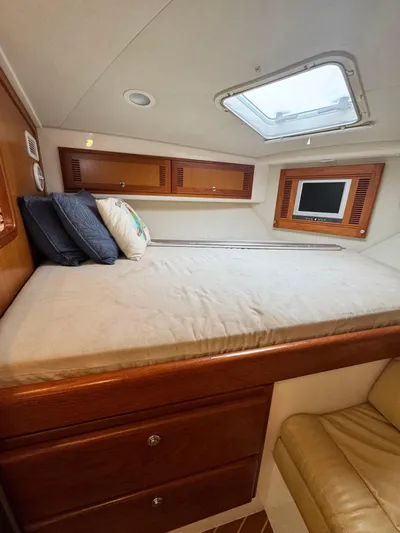 Fishy Business Yacht Photos Pics Cozy cabin interior of 2005 Cabo 35 Express with bed, storage, and porthole.
