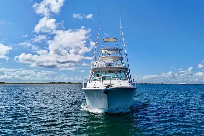 Fishy Business Yacht Photos Pics 2005 Cabo 35 Express boat cruising on open water under a clear blue sky.