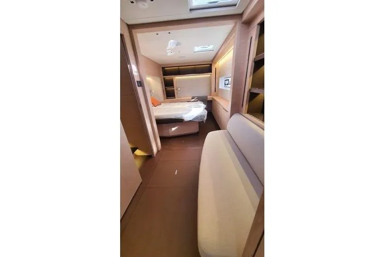 4ever Yacht Photos Pics Luxurious interior of 2022 Lagoon 67 yacht featuring a cozy bedroom and seating area.