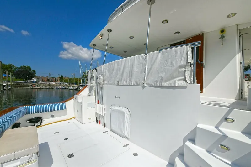 Symmetry Yacht Photos Pics 2002 Grand Alaskan Flushdeck yacht deck with white seating and marina view.