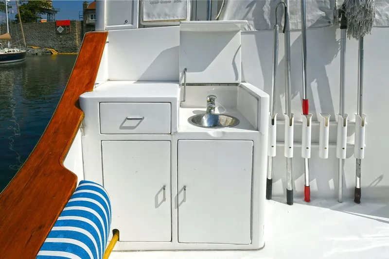 Symmetry Yacht Photos Pics 2002 Grand Alaskan Flushdeck yacht sink area with storage and cleaning tools.