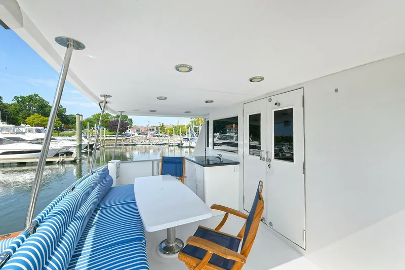 Symmetry Yacht Photos Pics 2002 Grand Alaskan Flushdeck yacht with outdoor seating and marina view.