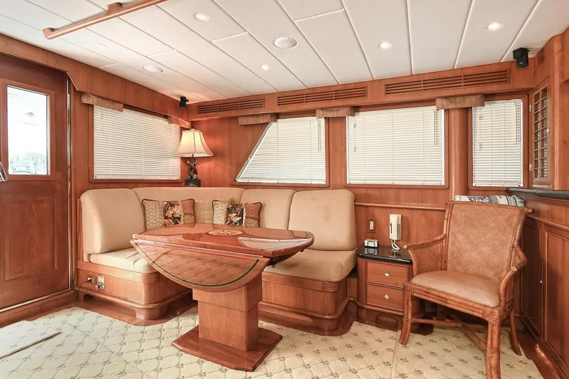 Symmetry Yacht Photos Pics Luxurious 2002 Grand Alaskan Flushdeck yacht interior with elegant wood paneling and cozy seating area.