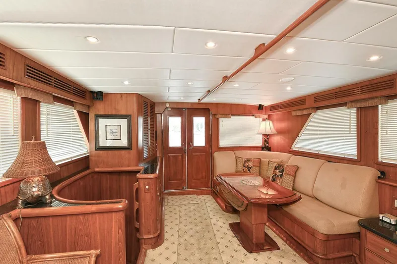 Symmetry Yacht Photos Pics Luxurious 2002 Grand Alaskan Flushdeck yacht interior with elegant wood finishes and cozy seating.