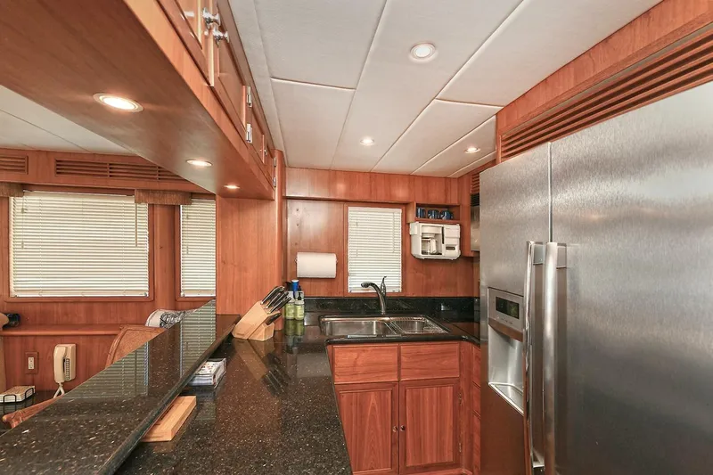 Symmetry Yacht Photos Pics Luxurious 2002 Grand Alaskan Flushdeck yacht kitchen with wood cabinetry and modern appliances.