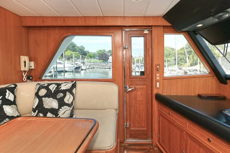 Symmetry Yacht Photos Pics Interior of 2002 Grand Alaskan Flushdeck yacht with wood paneling and marina view.