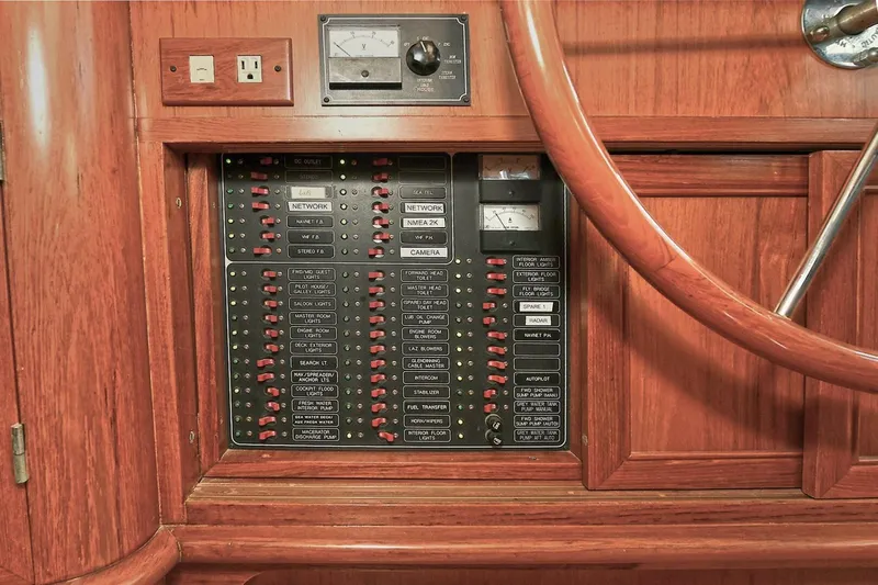 Symmetry Yacht Photos Pics Control panel of a 2002 Grand Alaskan Flushdeck yacht with wooden finish and steering wheel.