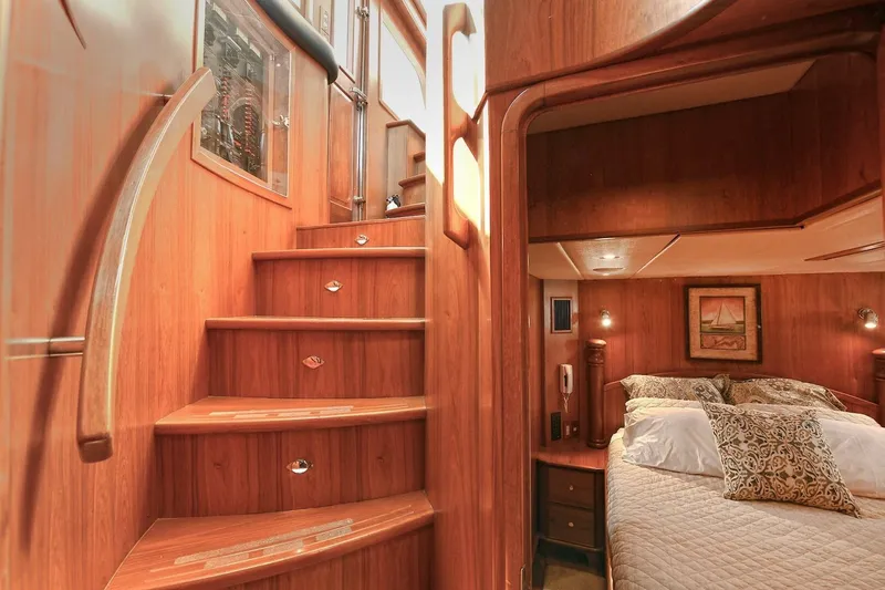 Symmetry Yacht Photos Pics Luxurious wooden interior of 2002 Grand Alaskan Flushdeck yacht with staircase and cozy bedroom.