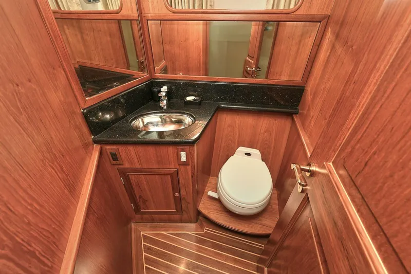 Symmetry Yacht Photos Pics Luxurious 2002 Grand Alaskan Flushdeck yacht bathroom with wood paneling and modern fixtures.