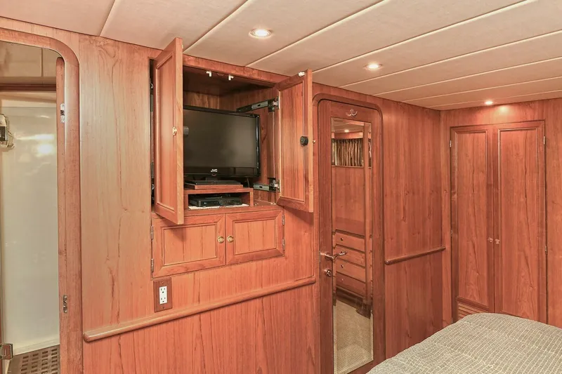 Symmetry Yacht Photos Pics Luxurious 2002 Grand Alaskan Flushdeck yacht interior with wood paneling and built-in TV cabinet.