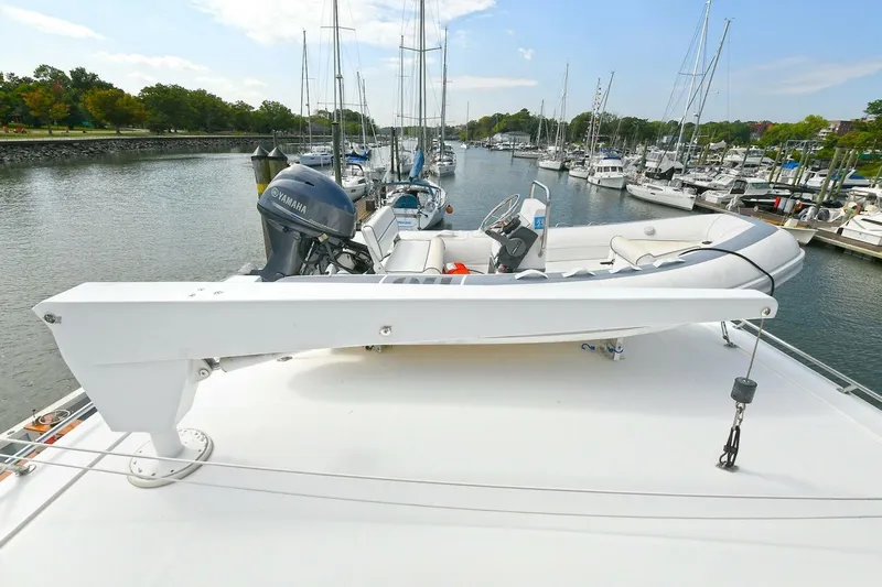 Symmetry Yacht Photos Pics 2002 Grand Alaskan Flushdeck yacht with dinghy on deck, docked in a marina.