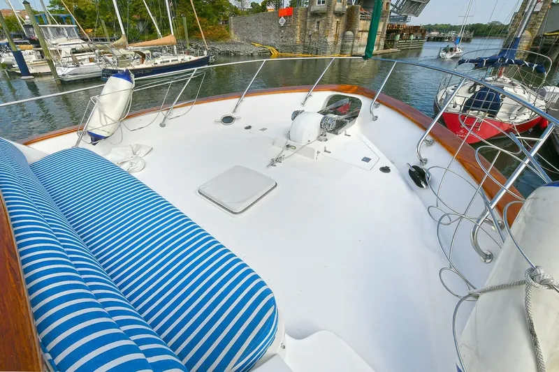 Symmetry Yacht Photos Pics 2002 Grand Alaskan Flushdeck yacht deck with striped seating, docked at marina.