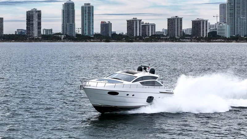  Yacht Photos Pics 2020 Pershing 62 yacht cruising near city skyline on open water.