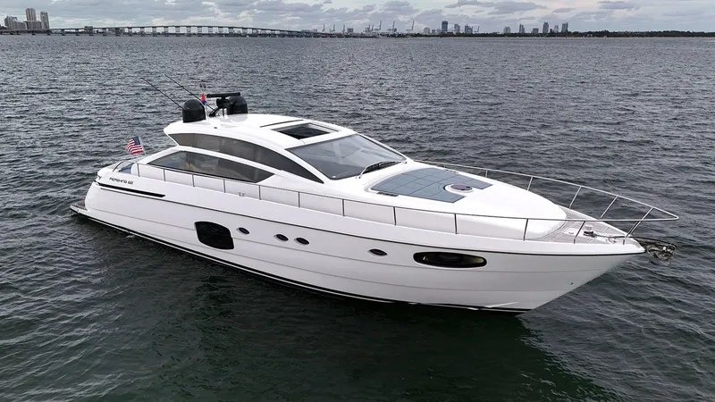  Yacht Photos Pics 2020 Pershing 62 yacht cruising on open water with city skyline in background.