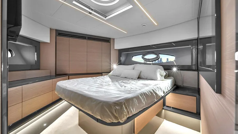  Yacht Photos Pics Luxurious bedroom interior of 2020 Pershing 62 yacht with modern design and ambient lighting.