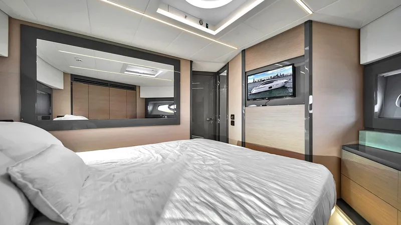  Yacht Photos Pics Luxurious bedroom interior of 2020 Pershing 62 yacht with modern decor and wall-mounted TV.