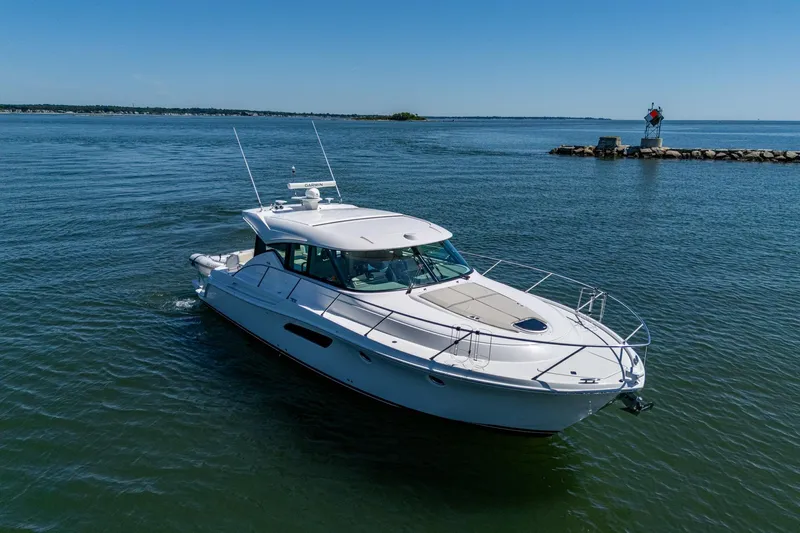  Yacht Photos Pics 2020 Tiara Yachts C44 Coupe cruising on calm waters under clear blue skies.