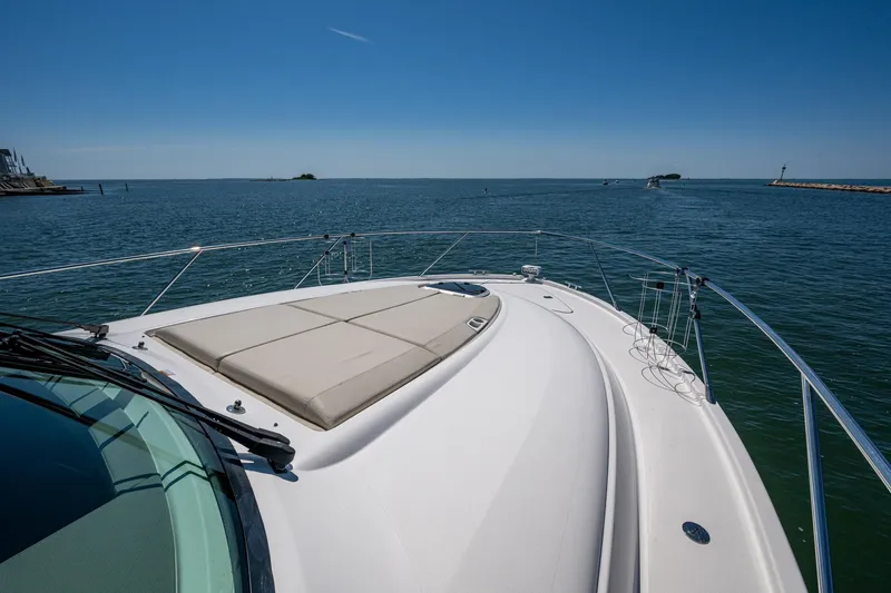  Yacht Photos Pics 2020 Tiara Yachts C44 Coupe cruising on open water under clear blue skies.