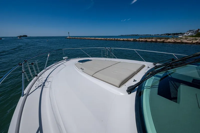  Yacht Photos Pics 2020 Tiara Yachts C44 Coupe cruising on a sunny day, featuring spacious deck and clear blue waters.