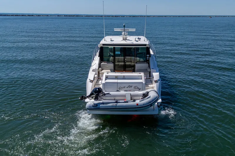  Yacht Photos Pics 2020 Tiara Yachts C44 Coupe on open water, rear view with inflatable boat.