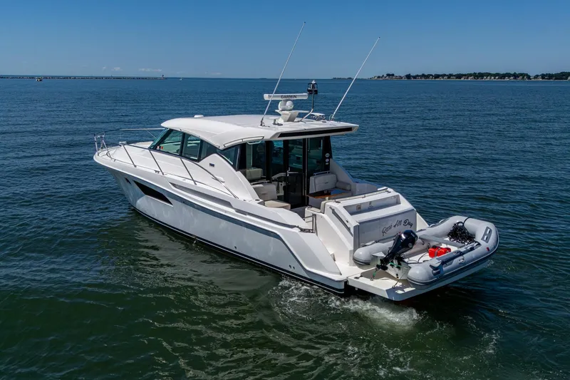  Yacht Photos Pics 2020 Tiara Yachts C44 Coupe cruising on open water, rear view.