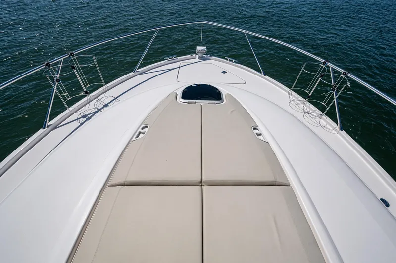  Yacht Photos Pics 2020 Tiara Yachts C44 Coupe bow with sunpad, surrounded by calm water.
