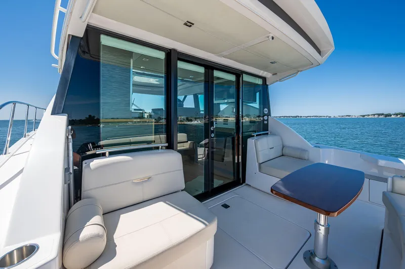  Yacht Photos Pics 2020 Tiara Yachts C44 Coupe, elegant deck with seating and table, ocean view.