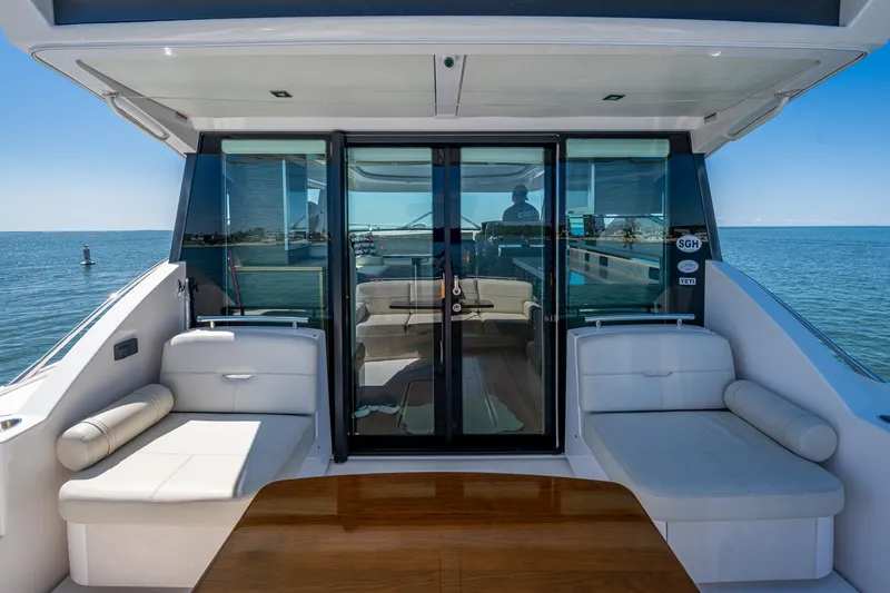  Yacht Photos Pics 2020 Tiara Yachts C44 Coupe, luxurious deck view with seating, ocean backdrop.