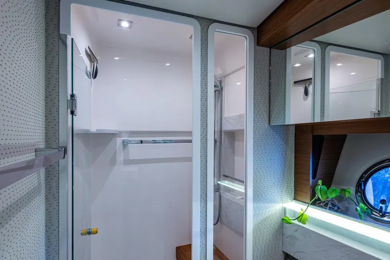  Yacht Photos Pics Luxurious bathroom interior of 2020 Tiara Yachts C44 Coupe with modern fixtures and porthole.