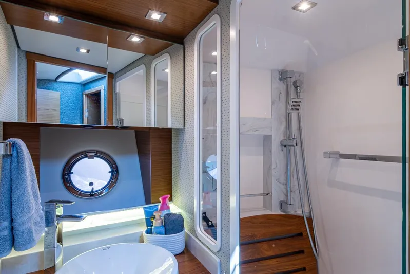  Yacht Photos Pics Luxurious bathroom interior of 2020 Tiara Yachts C44 Coupe with modern fixtures and porthole window.
