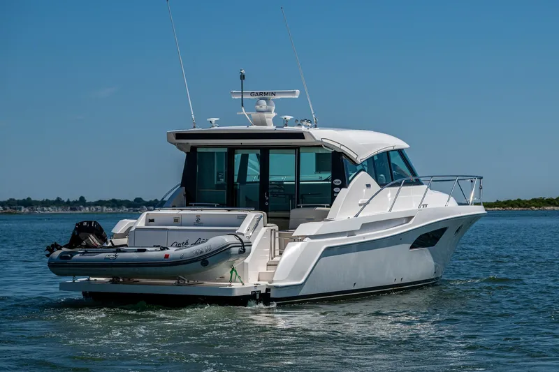  Yacht Photos Pics 2020 Tiara Yachts C44 Coupe cruising on open water, rear view.
