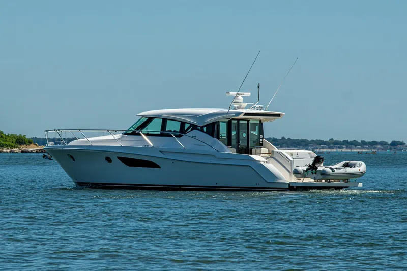  Yacht Photos Pics 2020 Tiara Yachts C44 Coupe cruising on open water, side view.