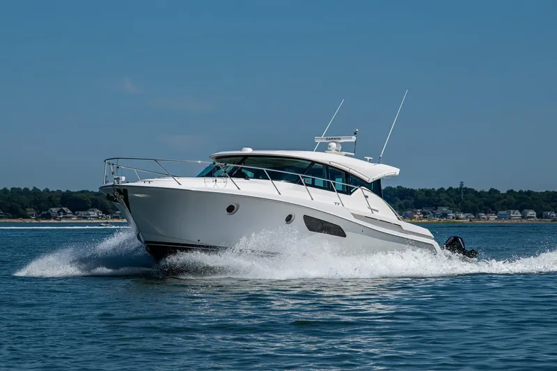  Yacht Photos Pics 2020 Tiara Yachts C44 Coupe cruising on open water, showcasing sleek design and performance.