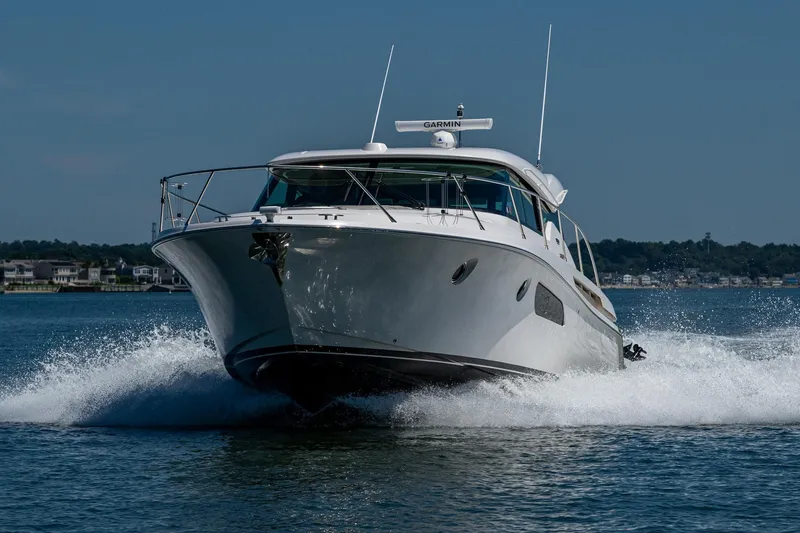  Yacht Photos Pics 2020 Tiara Yachts C44 Coupe cruising on water, showcasing sleek design and performance.