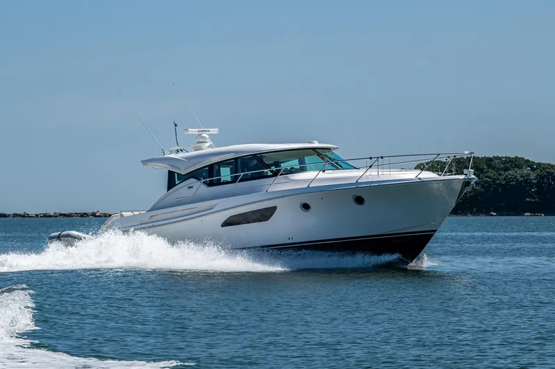  Yacht Photos Pics 2020 Tiara Yachts C44 Coupe cruising on open water, showcasing sleek design and performance.