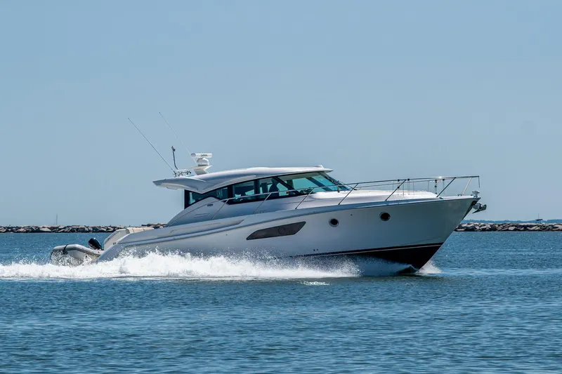  Yacht Photos Pics 2020 Tiara Yachts C44 Coupe cruising on open water, showcasing sleek design and performance.