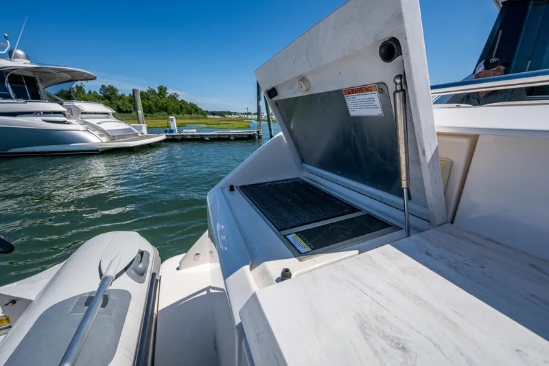  Yacht Photos Pics 2020 Tiara Yachts C44 Coupe with open grill on deck, docked by water.