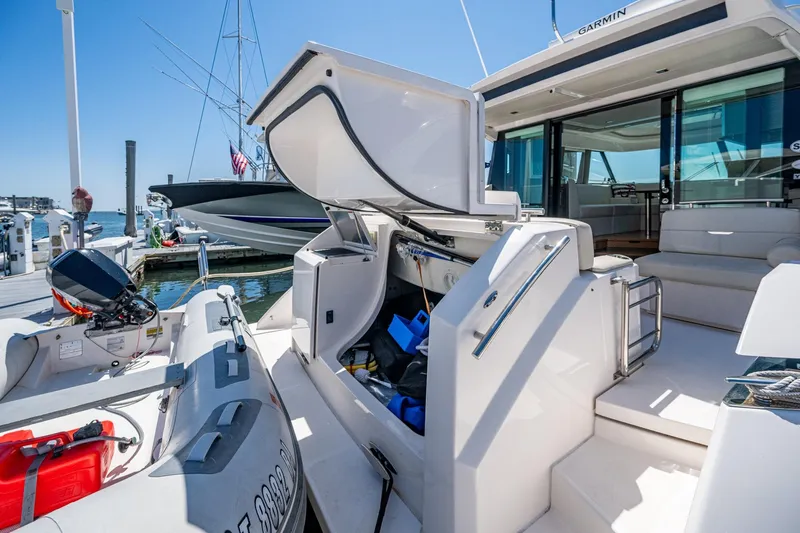  Yacht Photos Pics 2020 Tiara Yachts C44 Coupe at dock, open storage, inflatable boat nearby.