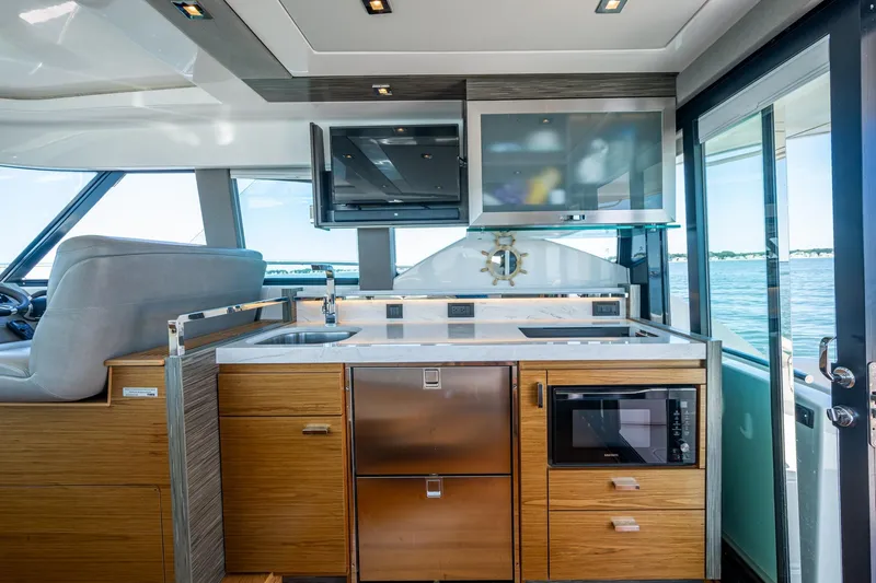  Yacht Photos Pics 2020 Tiara Yachts C44 Coupe interior with modern kitchen and ocean view.