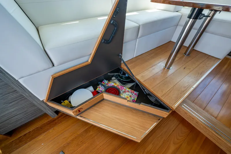  Yacht Photos Pics 2020 Tiara Yachts C44 Coupe interior storage compartment with wooden flooring and white seating.