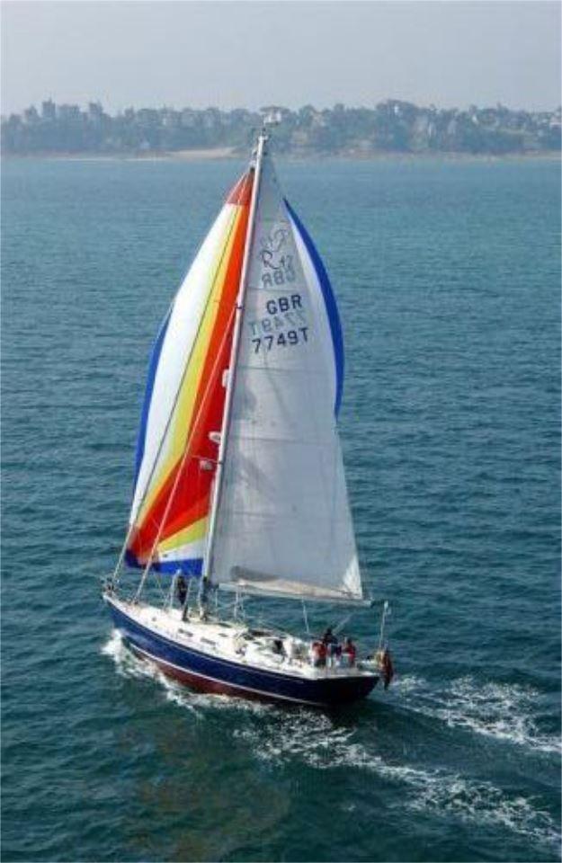 2025 Rustler 42 sailboat with colorful sails navigating on open water.