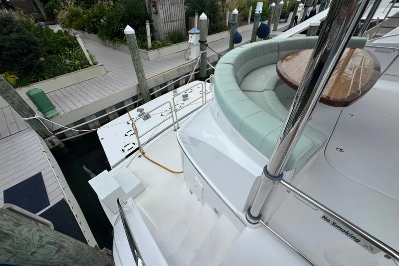 Elsewhere Yacht Photos Pics Hatteras 60 Motor Yacht 2013 docked, featuring a curved seating area and wooden table.