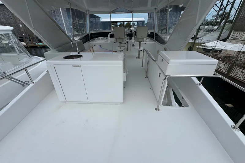Elsewhere Yacht Photos Pics 2013 Hatteras 60 Motor Yacht deck with seating and sink, docked at marina.