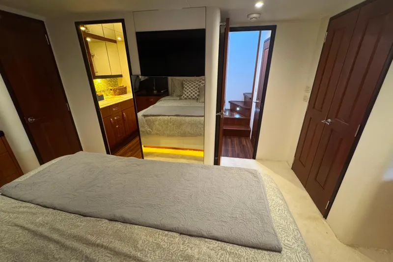 Elsewhere Yacht Photos Pics Luxurious bedroom interior of 2013 Hatteras 60 Motor Yacht with elegant wood finishes.